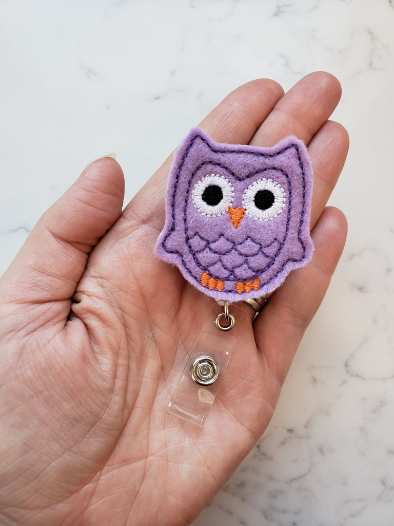 purple embroidered owl badge reel
